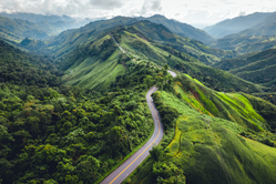 Long winding road on top of green mountain range